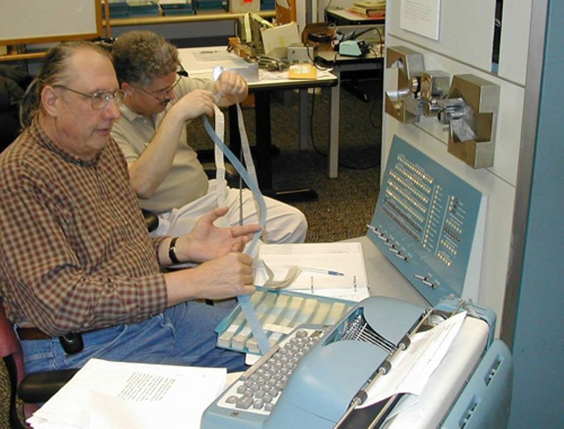 PDP-1 restoration team members, Lyle Bickley and Bob Lash examining paper tapes as part of the PDP-1 restoration project