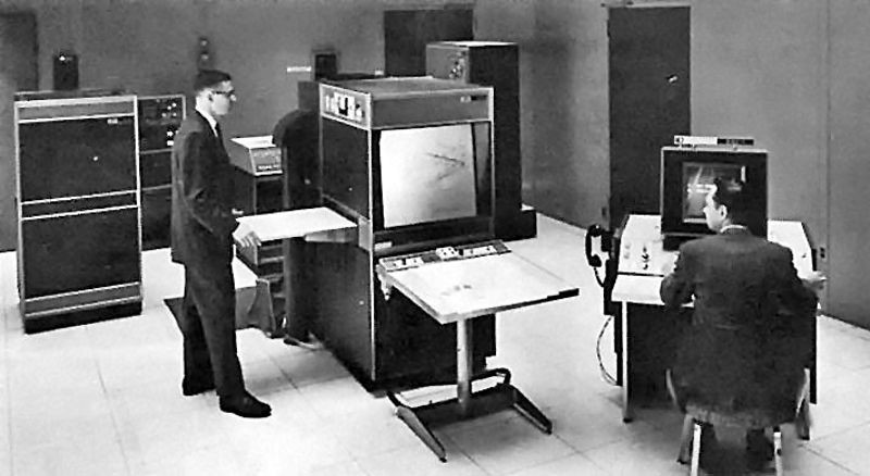 Black and white photo of two men working on large computers