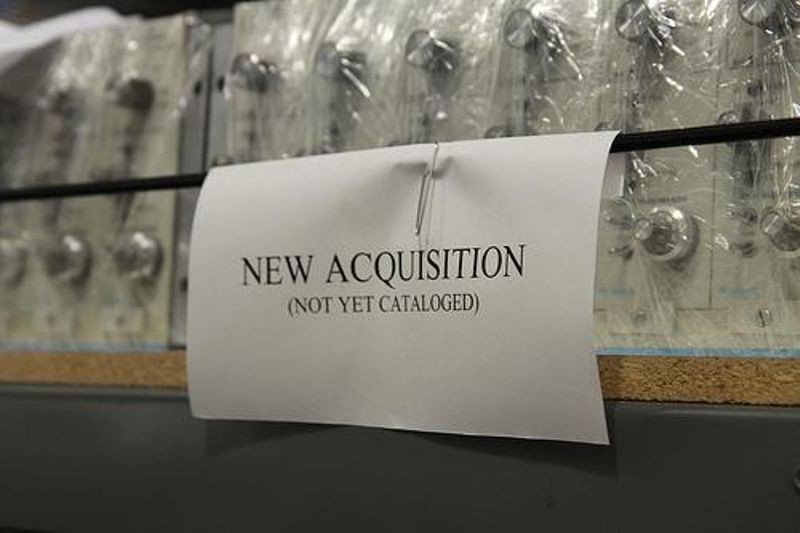 A sign indicates which shelves contain new materials waiting to be cataloged.