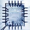 RCA 16-transistor MOS integrated circuit held in front of enlarged image